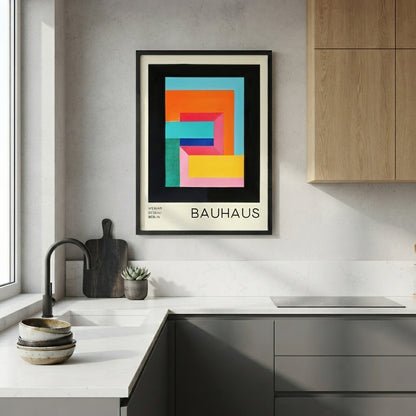 Framed Colorful Bauhaus exhibition print with typography and modernist design elements by PrintHaus in a modern kitchen with wooden cabinets and white countertops.