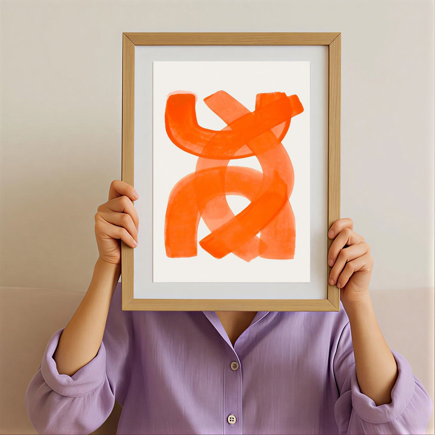 Person holding a framed abstract orange artwork against a neutral background