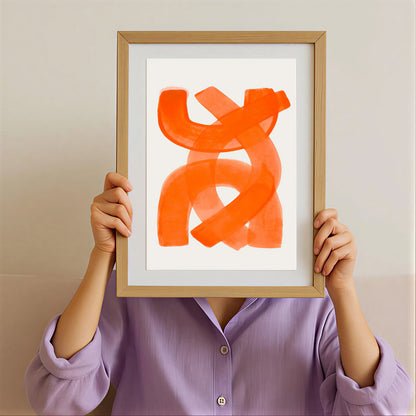 Person holding a framed abstract orange artwork against a neutral background