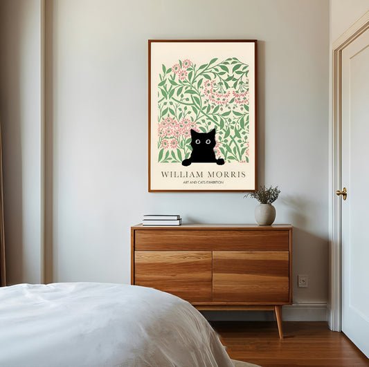 Framed William Morris Black Cat Print artwork with a black cat and floral design on a wall above a wooden dresser.
